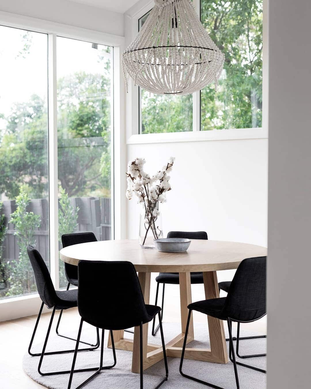 round oak dining table with black dining chairs | TLC Interiors